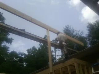 Carpenter setting a ridge beam over a new addition frame — Ice Dam Removal by Roofing Brothers in Rufus