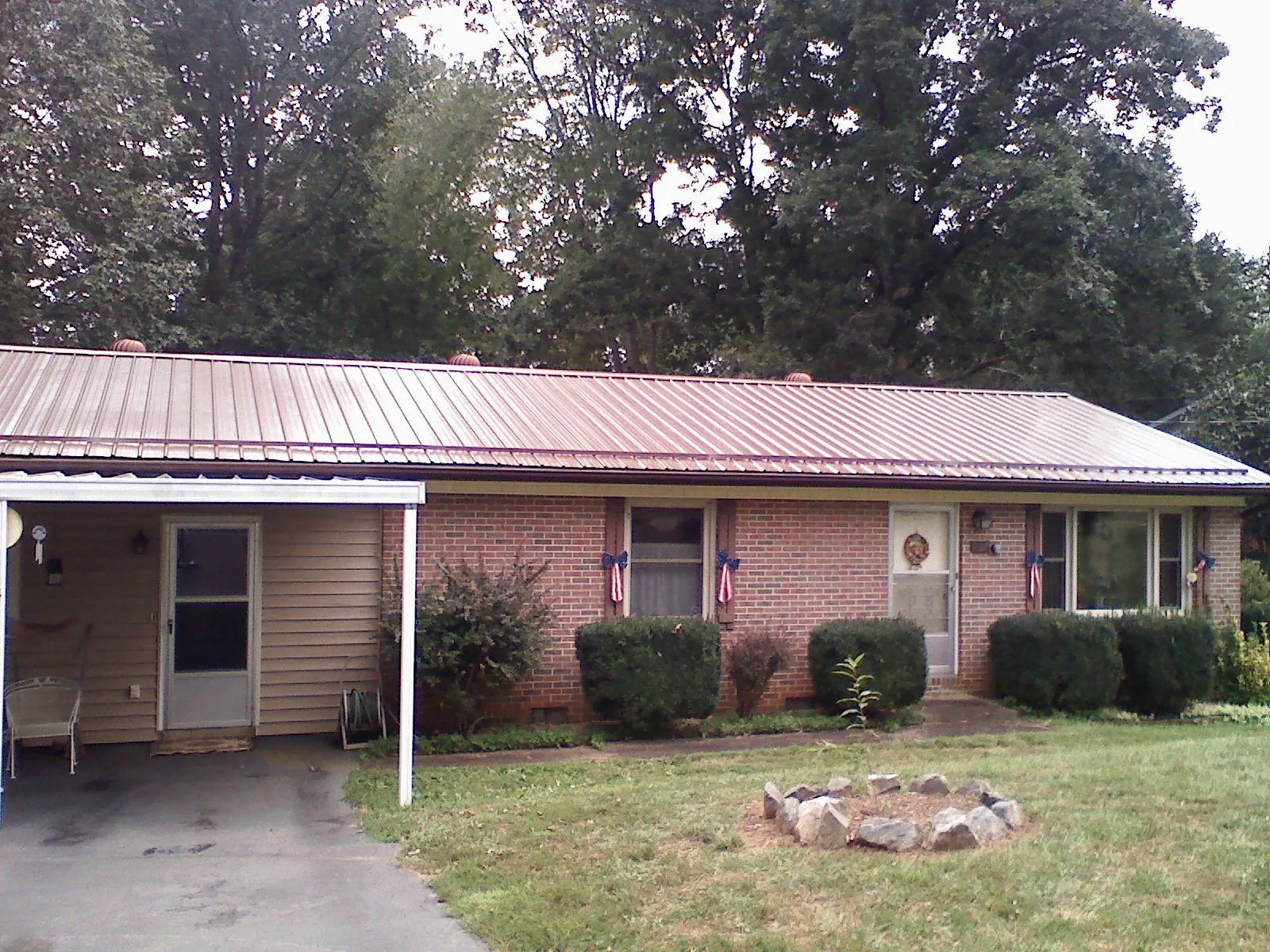 Bronze metal roof and carport on a brick ranch home — Roof Repair work by our crew in Rufus